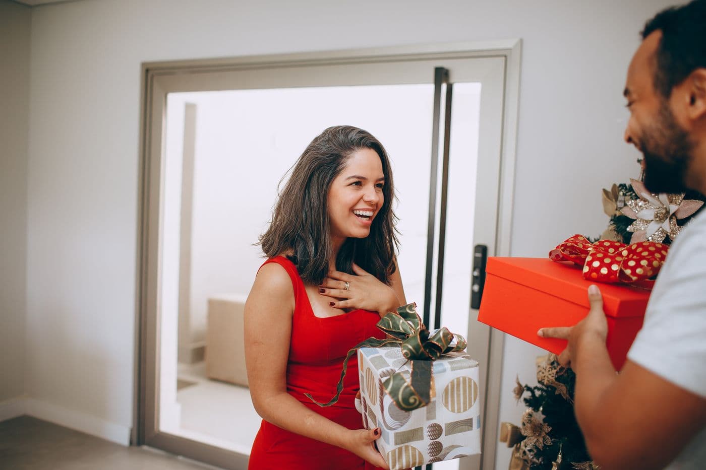 Mulher emocionada recebendo um presente do parceiro em casa